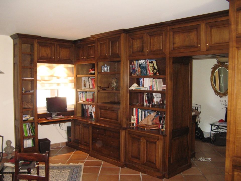 Agencement d'un séjour avec espaces bureau, bibliotheque, bar... en noyer et tilleul massif à Mercuer en Ardèche