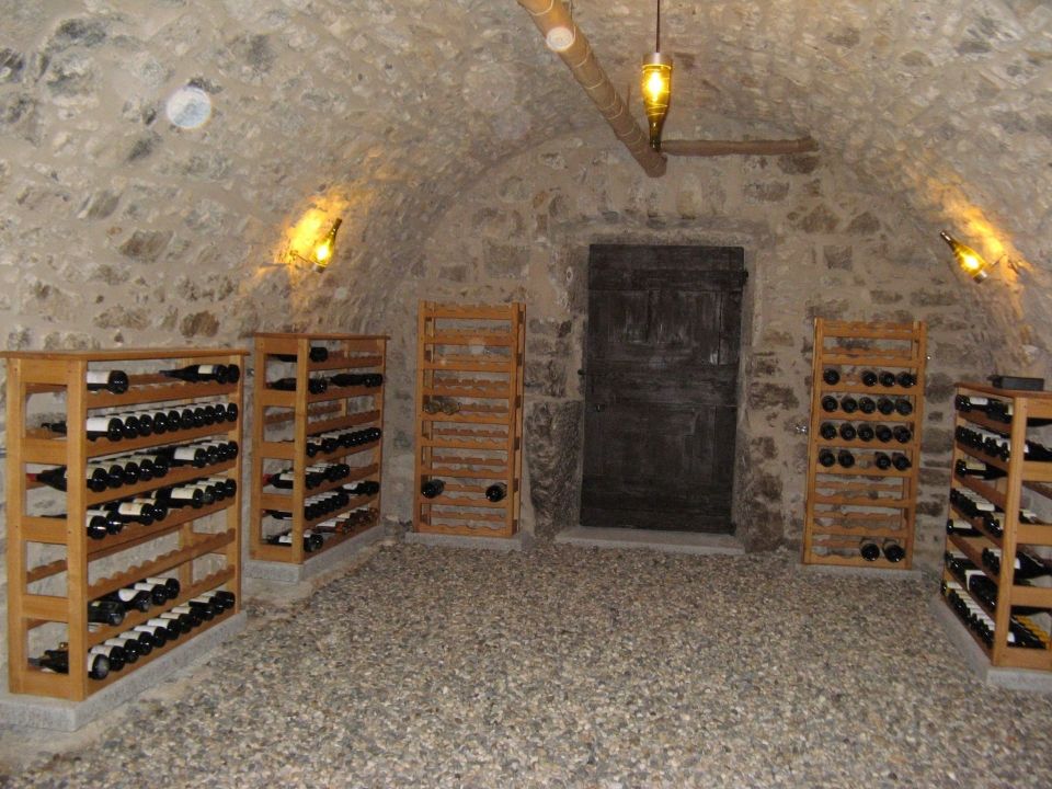 Meuble de cave à vin, rayonnage en chataignier massif pour le stockage de vin dans une maison ancienne à Vals les Bains