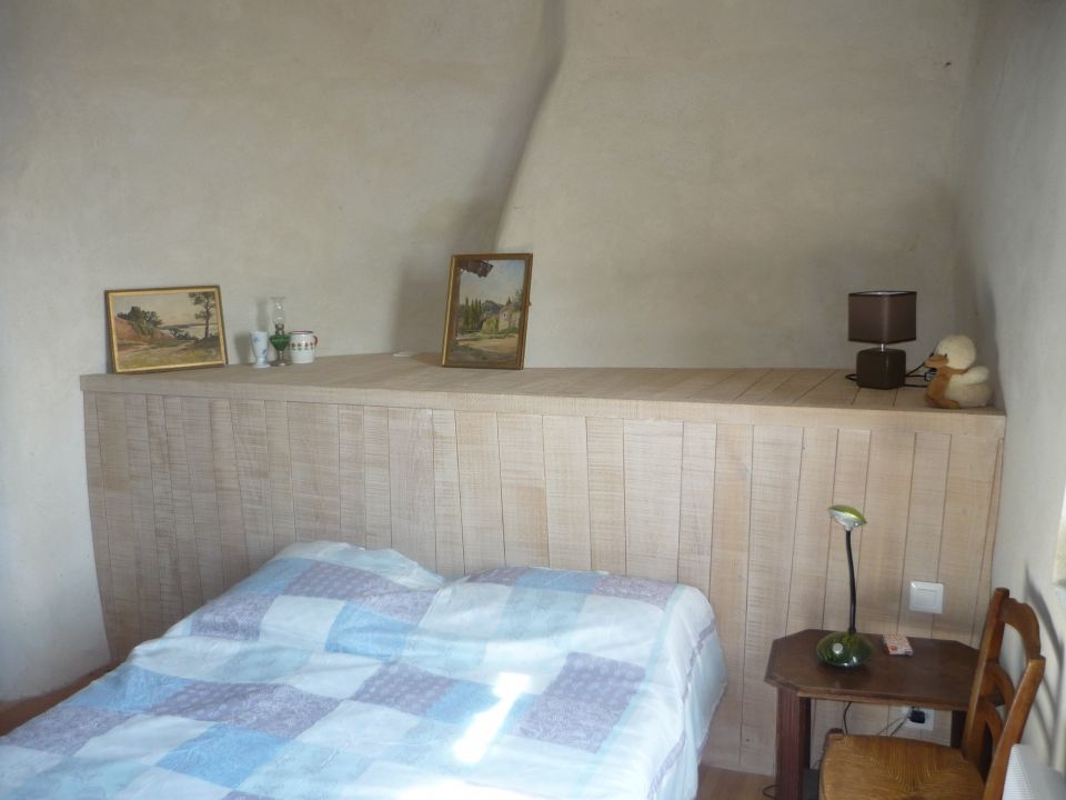 Tête de lit en chataignier brut de scie et patine à l'ancienne dans une maison ancienne à Vals les Bains - réalisation Atelier Vallon